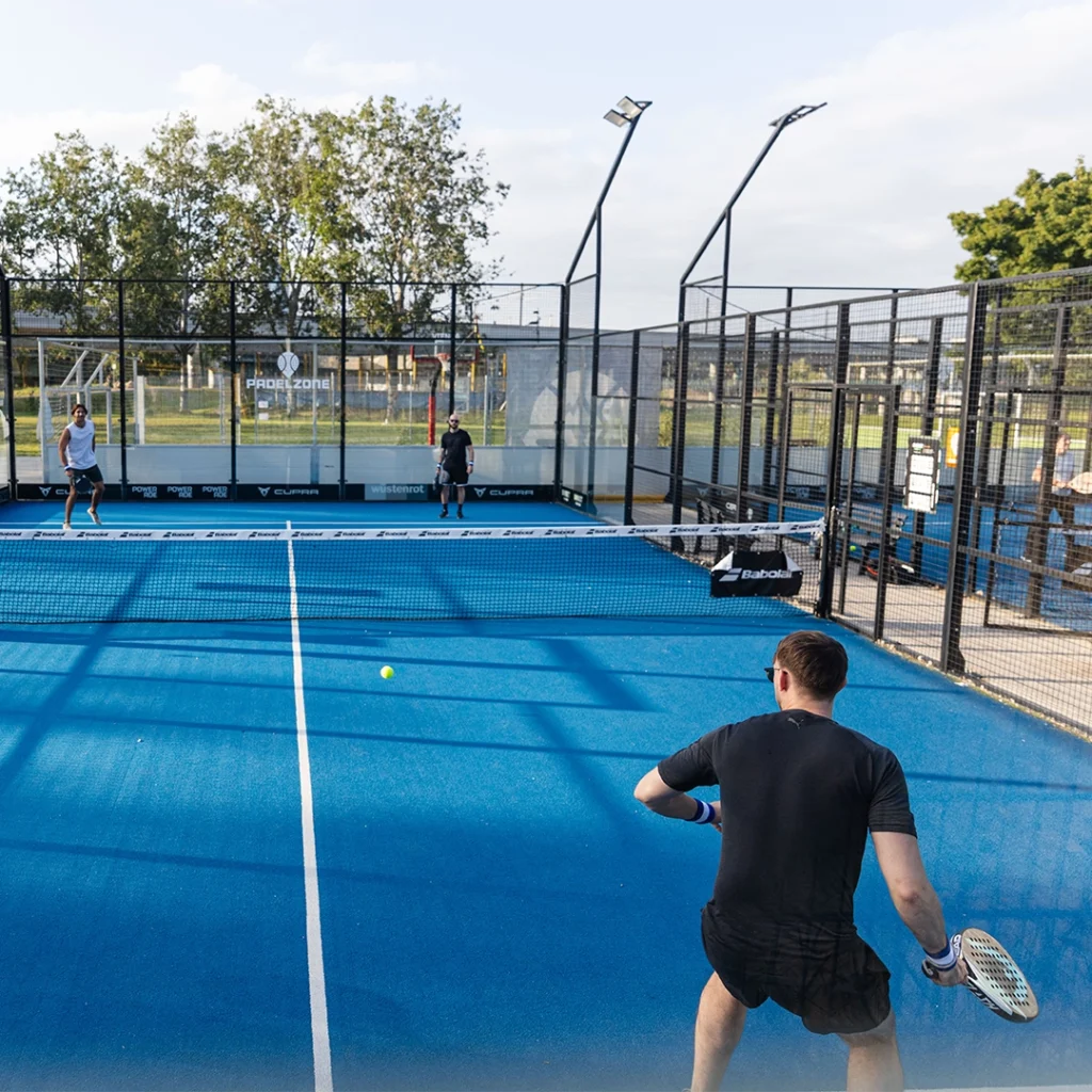 People playing Padel on a blue court at the Captain Athletic Club during a Founders Club networking event.